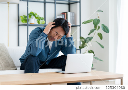 Middle man using a computer in the living room 125304080