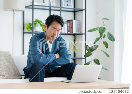 Middle man using a computer in the living room 125304082