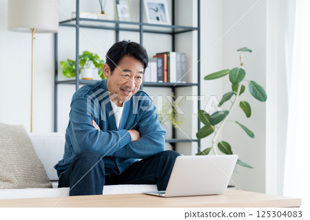 Middle man using a computer in the living room 125304083