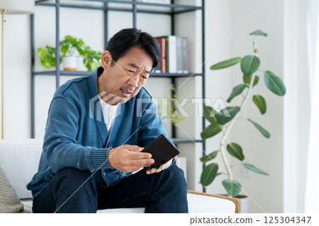 Middle-aged man struggling with wallet 125304347