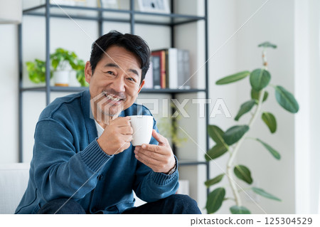 Middle man drinking coffee in the living room 125304529