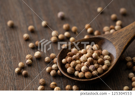 Close-up of coriander seeds on a wooden spoon 125304553