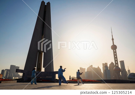 Chinese people practice Tai Chi at Bund with pearl tower in sunrise, Shanghai Chinese people practice Tai Chi at Bund with pearl tower in sunrise, Shanghai 125305214