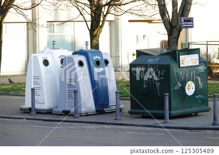 Glass recycling containers for clear, mixed, and colored glass in a city setting. 125305489