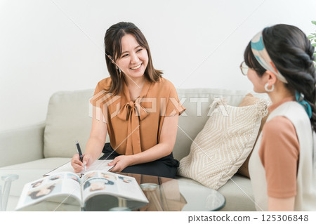 Hairdresser / stylist and customer woman (counseling sheet) counseling at beauty salon / hair salon Hairdresser / stylist and customer woman (counseling sheet) counseling at beauty salon / hair salon 125306848