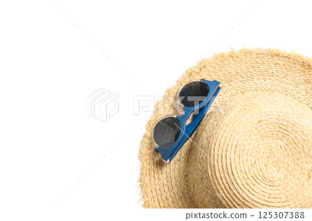 Straw hat with sunglasses laid next to it, perfect for summer travel, isolated on white Straw hat with sunglasses laid next to it, perfect for summer travel, isolated on white 125307388