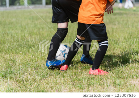 Close-up of two boys competing for soccer ball. Close-up of two boys competing for soccer ball. 125307636