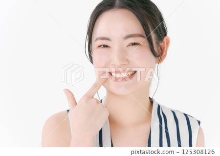 指著她的牙齒的年輕女子 125308126