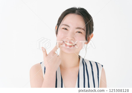 Young woman pointing to teeth 125308128