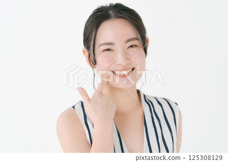 指著她的牙齒的年輕女子 125308129