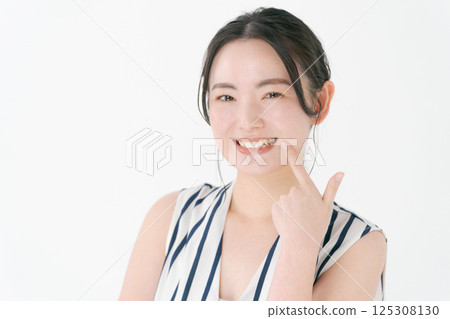 指著她的牙齒的年輕女子 125308130