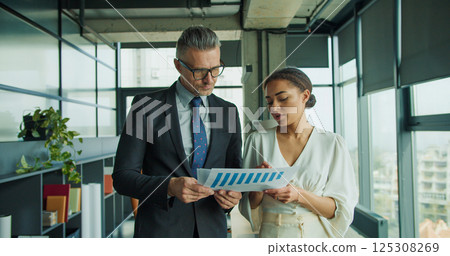 Businessman and woman review a financial report 125308269