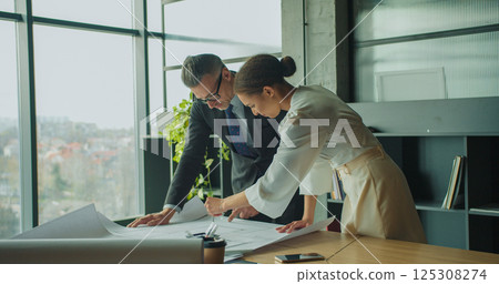 Architects discussing floor plan in modern office 125308274