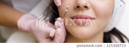 Face lifting PDO Suture operation. innovative technique of New thread lift, cosmetologist preparing to do procedure to female client, select the appropriate thread option Face lifting PDO Suture operation. innovative technique of New thread lift, cosmetologist preparing to do procedure to female client, select the appropriate thread option 125308713