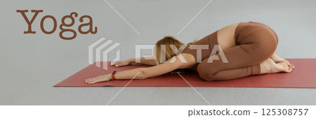 attractive girl practices yoga stretching in non-hard exercises, Balasana pose, close-up, train in a club, studio 125308757