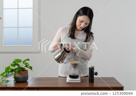 A woman brewing coffee by hand drip 125309094