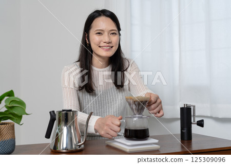 A woman brewing coffee by hand drip 125309096