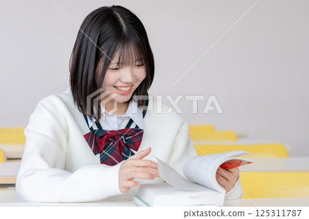 一名女學生微笑地看著教材 125311787