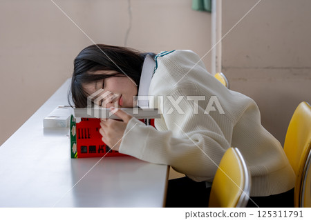 一名女學生正睡眼惺忪地學習 125311791