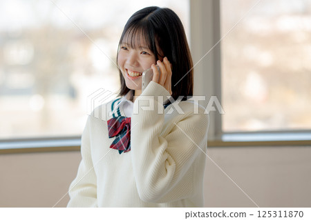 Smiling student making a phone call 125311870