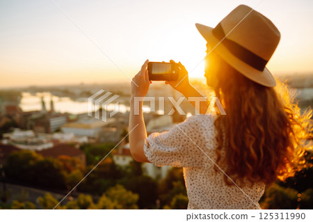 Travel in Europe. Young woman enjoys sunrise. The concept of travel, tourism, vacation and freedom. Travel in Europe. Young woman enjoys sunrise. The concept of travel, tourism, vacation and freedom. 125311990