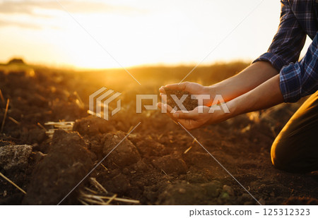 Farm owner checks quality of soil with his hands with tablet and checks fertility before sowing. 125312323