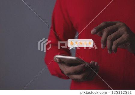 Young Man hand holding Smart Phone with five star to review and give 5 stars 125312551