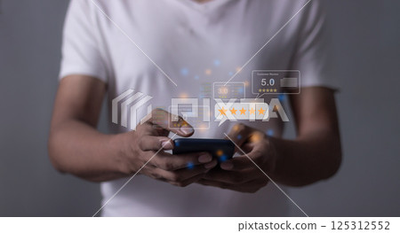 Young Man hand holding Smart Phone with five star to review and give 5 stars 125312552