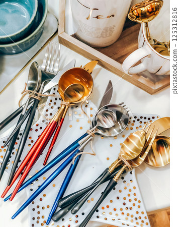 Colorful cutlery sets with wooden handles on white polka dot plates Colorful cutlery sets with wooden handles on white polka dot plates 125312816