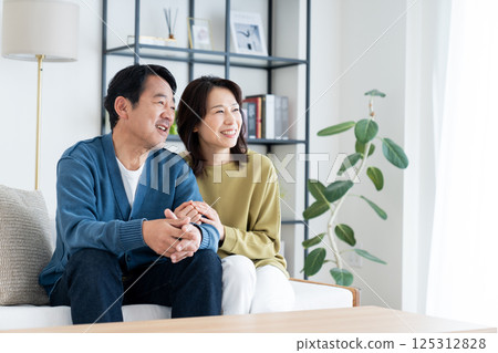 A middle-aged couple relaxing in the living room 125312828