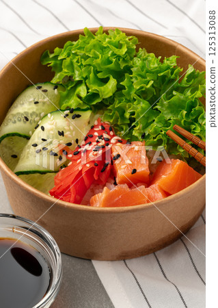 Healthy sushi bowl with salmon, fresh vegetables, and sesame seeds for a nutritious meal option 125313088
