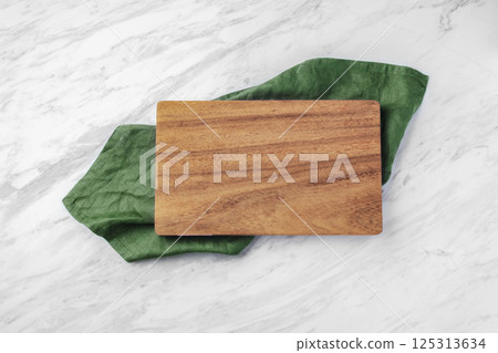Wood board on green kitchen cloth on natural marble table Wood board on green kitchen cloth on natural marble table 125313634