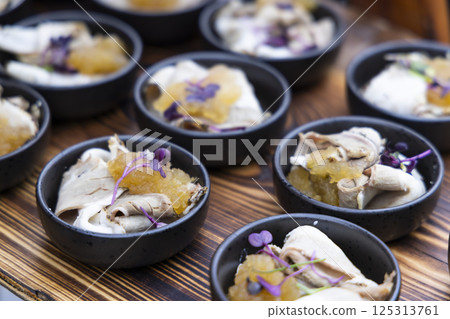 Catering company preparing delicious canapes with meat, sauce and microgreens Catering company preparing delicious canapes with meat, sauce and microgreens 125313761