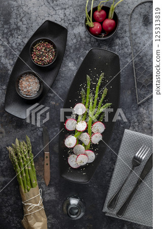 Preparing fresh asparagus and radish salad with mixed pepper and himalayan salt Preparing fresh asparagus and radish salad with mixed pepper and himalayan salt 125313819