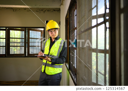 Site supervisor using digital tablet to inspect and manage residential construction 125314567