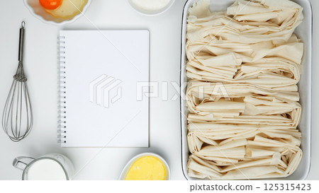 Mockup design for recipe or food blog. Cooking ingredients and notebook on a white background. For baking Crinkle Cake 125315423