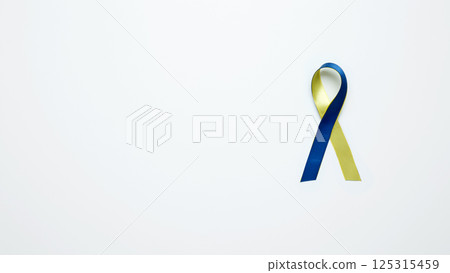 Symbolizing World Down Syndrome Day. A yellow and blue awareness ribbon Symbolizing World Down Syndrome Day. A yellow and blue awareness ribbon 125315459