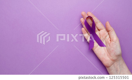 Purple ribbon held, symbol of support.Purple Epilepsy Awareness Day Purple ribbon held, symbol of support.Purple Epilepsy Awareness Day 125315501