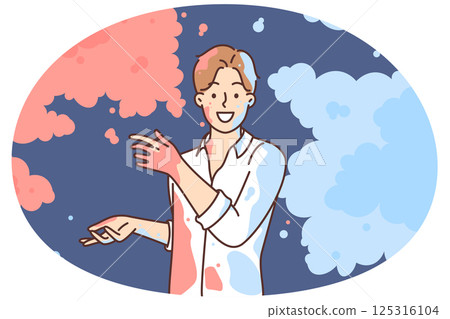 Man in white shirt scatters multi-colored powder on sides, wanting to share bright emotions 125316104