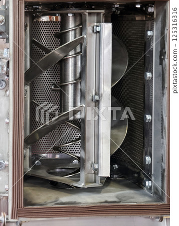Industrial mixing machine shows rotating blades and stainless steel interior in factory environment Industrial mixing machine shows rotating blades and stainless steel interior in factory environment 125316316