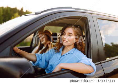 Two young women on car trip having fun. Lifestyle, travel, tourism, nature, active life. 125317154
