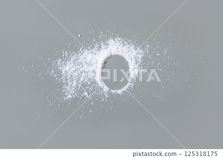 White powder on grey with copy space in middle top view. Dietary supplement or kitchen spice 125318175