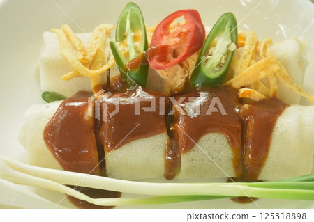 fresh Chinese spring roll made from flour wrapped tofu and pork with bean sprout dressing sweet red gravy sauce on plate    125318898