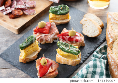 Traditional Spanish pintxos on wooden table 125319007