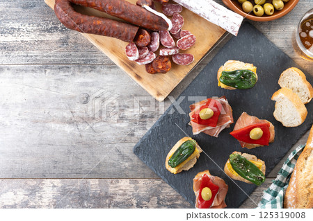 Traditional Spanish pintxos on wooden table 125319008