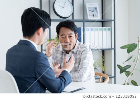 A middle-aged man consulting with a planner A middle-aged man consulting with a planner 125319052