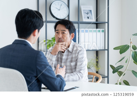 A middle-aged man consulting with a planner A middle-aged man consulting with a planner 125319059