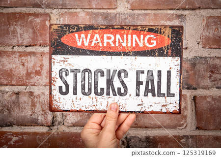 STOCKS FALL. Warning sign with text in the hand 125319169