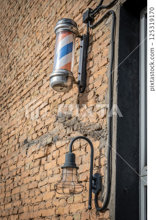 Vintage Barber Shop Pole and Industrial Light on Brick Wall 125319170