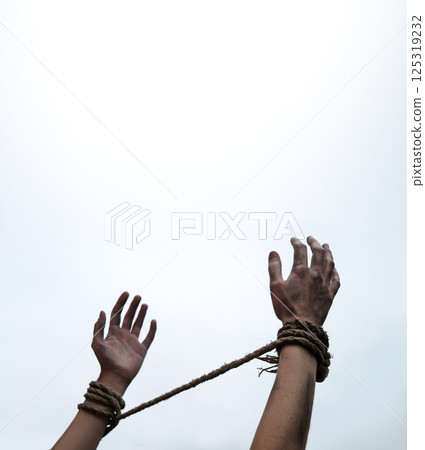 Tied hands raised to the sky 125319232